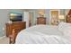 This bedroom is spacious and includes an ensuite bathroom and a television on a wooden dresser at 3712 59Th Avenue E Cir, Ellenton, FL 34222