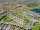 A beautiful aerial view showcases a residential community featuring manicured lawns, lush landscaping, and circular intersection at 3835 Autumn Fern Ter, Sarasota, FL 34243