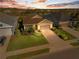 Aerial view of a well-maintained home with a manicured lawn and mature landscaping at sunset at 3835 Autumn Fern Ter, Sarasota, FL 34243