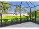 Screened patio with a view of the lush backyard featuring manicured landscaping and mature trees at 3835 Autumn Fern Ter, Sarasota, FL 34243