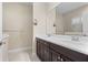 Bathroom features a dual vanity with dark wood cabinets, a large mirror, and tiled floors, offering a clean design at 3835 Autumn Fern Ter, Sarasota, FL 34243
