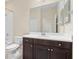 Bathroom with white countertops, dark cabinetry, mirror, and combined shower and bathtub at 3835 Autumn Fern Ter, Sarasota, FL 34243