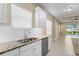 Bright kitchen featuring granite counters, stainless steel appliances, and white shaker cabinets at 3835 Autumn Fern Ter, Sarasota, FL 34243