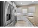 Modern kitchen featuring stainless steel appliances, white cabinets, and granite countertops at 3835 Autumn Fern Ter, Sarasota, FL 34243