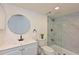 Updated bathroom features a sleek vanity, a modern round mirror, and a frameless glass shower at 425 30Th W Ave # C201, Bradenton, FL 34205