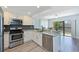 Modern kitchen features stainless appliances, granite counters, and sleek gray tile backsplash at 425 30Th W Ave # C201, Bradenton, FL 34205