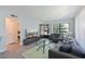 The well-lit living room includes a view of the front door, a large tv, and neutral-colored decor at 425 30Th W Ave # C201, Bradenton, FL 34205