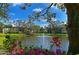 Scenic view of the condo community's pond featuring a fountain, gazebo and colorful floral landscaping at 425 30Th W Ave # C201, Bradenton, FL 34205