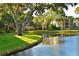Scenic view of the community grounds featuring a lush lawn, mature tree and pond at 425 30Th W Ave # C201, Bradenton, FL 34205