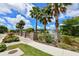 Beautiful street view with palm trees, sidewalk and a glimpse of pond with fountain at 4702 Vasca Dr, Sarasota, FL 34240