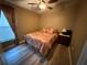 Cozy bedroom with wood-look flooring, ceiling fan, and a matching lamps and curtains at 509 Stone Briar Dr, Ruskin, FL 33570