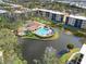 An aerial view shows a community pool, clubhouse, and a scenic pond surrounded by lush greenery at 515 30Th Ave W # H410, Bradenton, FL 34205