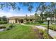 Exterior of community clubhouse with lush landscaping, walkways, and a tranquil pond, enhancing the building's appeal at 515 30Th Ave W # H410, Bradenton, FL 34205