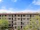A tan apartment building featuring dark wood railings and stairwells, complemented by lush green landscaping around the building at 515 30Th Ave W # H410, Bradenton, FL 34205
