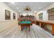 Spacious game room with a pool table, bookshelf, wood flooring, and natural lighting, perfect for relaxation and entertainment at 515 30Th Ave W # H410, Bradenton, FL 34205