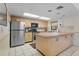Well-lit kitchen features stainless steel appliances and ample counter space with tile flooring at 515 30Th Ave W # H410, Bradenton, FL 34205