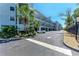 Exterior view of a condo building with a parking area and palm trees at 515 Leffingwell Ave # 210, Ellenton, FL 34222