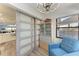 Light-filled living area with modern light fixture, blue chair, and balcony views at 515 Leffingwell Ave # 210, Ellenton, FL 34222