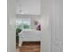 Bright bedroom with wood floors and a white bed, bathed in natural light from large windows at 5211 Mahogany Run Ave # 126, Sarasota, FL 34241