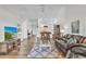 Spacious living room featuring wood floors, a large leather sofa, and open access to dining and kitchen areas at 5211 Mahogany Run Ave # 126, Sarasota, FL 34241