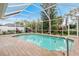 A screened-in pool with a metal ladder surrounded by a wooden deck and lush landscaping, provides a relaxing outdoor space at 5662 Country Lakes Dr, Sarasota, FL 34243