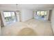 Spacious living room with patio access and a stylish chandelier, offering an indoor-outdoor flow at 5684 Sheffield Greene Cir # 79, Sarasota, FL 34235