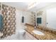 Well-lit bathroom featuring a shower with colorful curtain and granite countertop at 5814 Garden Lakes Fern, Bradenton, FL 34203