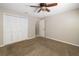 Carpeted bedroom with a ceiling fan, a closet, and access to additional rooms at 5814 Garden Lakes Fern, Bradenton, FL 34203