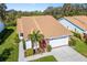 Aerial view of a well-maintained home with a tile roof, lush landscaping, and an attached garage at 5814 Garden Lakes Fern, Bradenton, FL 34203