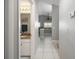 Hallway leading to an open living space, showcasing a bathroom and tile flooring at 5814 Garden Lakes Fern, Bradenton, FL 34203