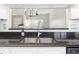 Close-up on stainless-steel sink with granite countertops and view into the living room at 5814 Garden Lakes Fern, Bradenton, FL 34203