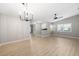 Bright living room features wood-look flooring, modern light fixture, and large windows at 5814 Garden Lakes Fern, Bradenton, FL 34203