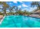 Community pool surrounded by trees and lounge chairs, offering a relaxing atmosphere at 5814 Garden Lakes Fern, Bradenton, FL 34203