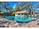 Community pool with clean water surrounded by trees, lounge chairs and a small building at 5814 Garden Lakes Fern, Bradenton, FL 34203