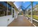 A screened in porch with white walls and a concrete floor, offering an inviting outdoor retreat at 5814 Garden Lakes Fern, Bradenton, FL 34203