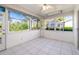 Bright sunroom with large windows offering scenic views of the surrounding greenery, tile floor and ceiling fan at 5814 Garden Lakes Fern, Bradenton, FL 34203