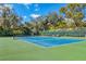 Community tennis court surrounded by mature trees providing shade and privacy at 5814 Garden Lakes Fern, Bradenton, FL 34203