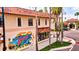 A building exterior boasts colorful mural and architectural details, framed by palm trees at 603 Ravenna N St, Nokomis, FL 34275