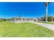 The house sits on a lush green lawn, accented by mature trees and a well-manicured landscape at 603 Ravenna N St, Nokomis, FL 34275