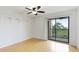 Light filled bedroom with wood floors, fan and balcony access at 6124 43Rd W St # 404A, Bradenton, FL 34210