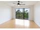 Bedroom features a ceiling fan, laminate floors, and a sliding glass door to the balcony at 6124 43Rd W St # 404A, Bradenton, FL 34210