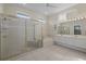 Well-lit bathroom featuring a luxurious walk-in shower, tub, and dual sinks at 6766 Greenview Ln, Englewood, FL 34224
