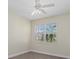 Well-lit bedroom with neutral walls, ceiling fan, plantation shutters, and wood-look flooring at 6766 Greenview Ln, Englewood, FL 34224