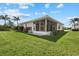 Exterior view of the home featuring a screened in lanai and well maintained lawn at 6766 Greenview Ln, Englewood, FL 34224