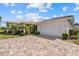 Charming single-story home boasts a brick driveway, manicured landscaping and an attached two-car garage at 6766 Greenview Ln, Englewood, FL 34224
