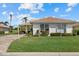 Charming single-story home featuring a well-manicured lawn, mature landscaping, and a welcoming paver driveway at 6766 Greenview Ln, Englewood, FL 34224