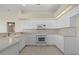 Bright kitchen featuring white cabinets and neutral countertops with view to the dining area at 6766 Greenview Ln, Englewood, FL 34224