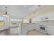 Bright kitchen area with white cabinets, tile floors and a view of the lanai at 6766 Greenview Ln, Englewood, FL 34224
