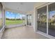 Enclosed lanai featuring sliding glass doors overlooking a lush green lawn at 6766 Greenview Ln, Englewood, FL 34224