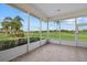 Enclosed lanai with a lush green lawn and tropical landscaping at 6766 Greenview Ln, Englewood, FL 34224